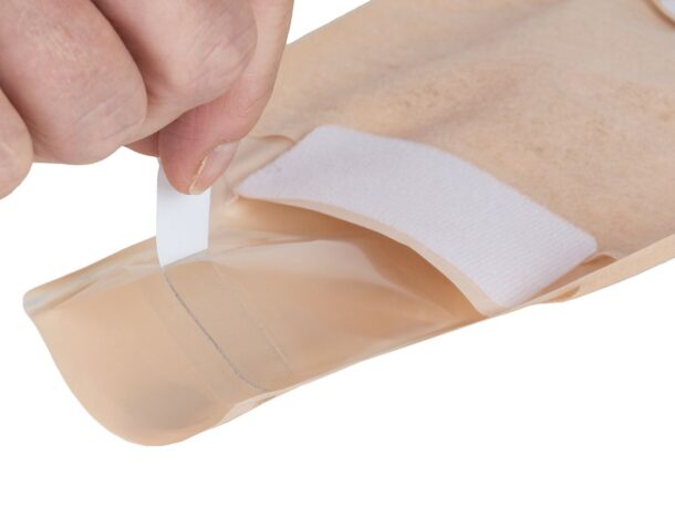 Aura convex drainable with a hand removing the release liner of the drainage