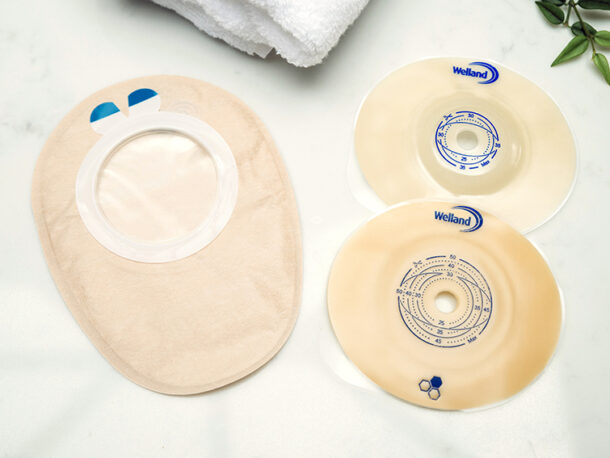 Aura Flushable outer cover and two flanges flat and convex with towel and plant.