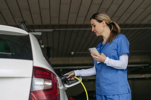 nurse using EV charger with car