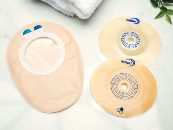 Aura Flushable outer cover and two flanges flat and convex with towel and plant.