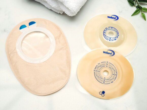 Aura Flushable outer cover and two flanges flat and convex with towel and plant.