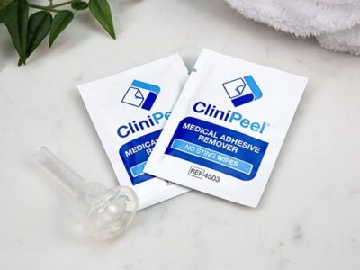 Two CliniPeel wipes next to a CliniSure Urinary Sheath on a marble countertop