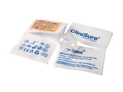 A CliniSure Urinary Sheath on top of its open packaging which is a paper sachet that has been split four ways.