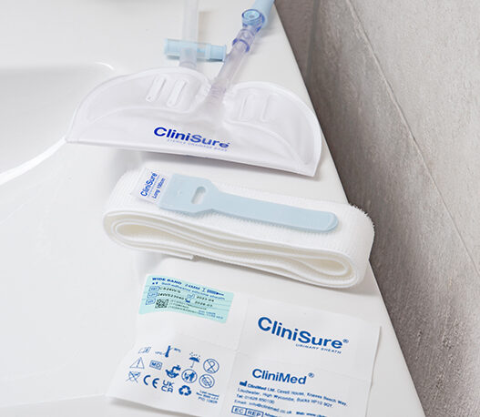 A CliniSure sheath package, a CliniSure retaining strap and a CliniSure leg bag on the side of a sink.