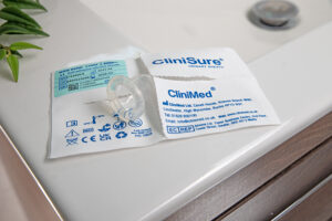 A CliniSure sheath sticking out of its packaging on the corner of a sink.