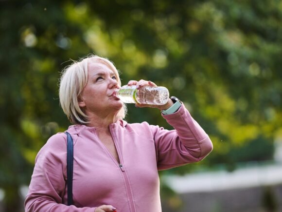 Lady drinking water from a bottle whilst outside