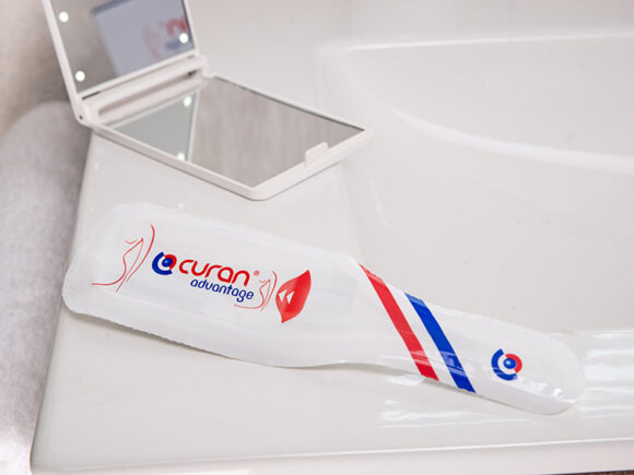 Curan advantage female catheter on a bathroom sink with a mirror and a towel.