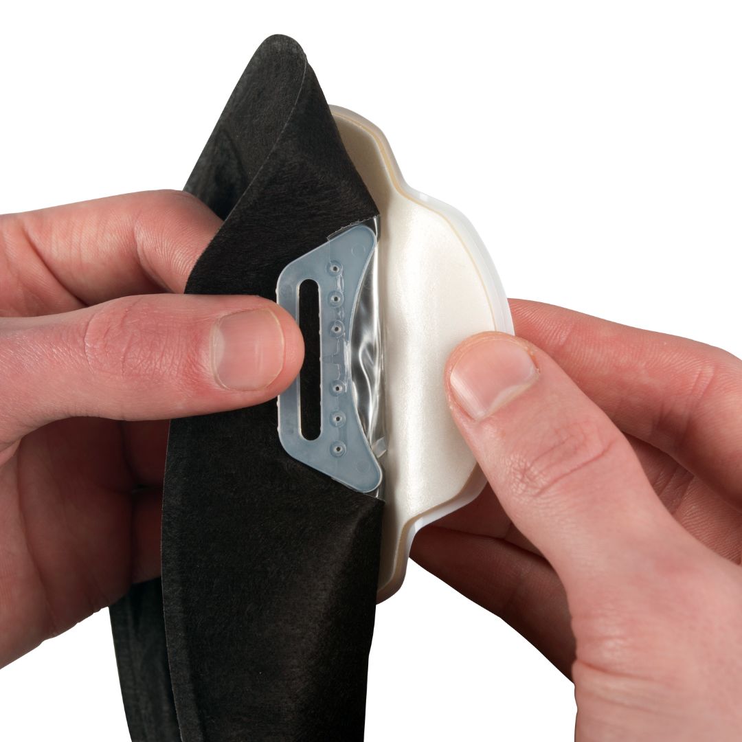 Hands hold an Aura Plus stoma bag demonstrating the soft belt loops