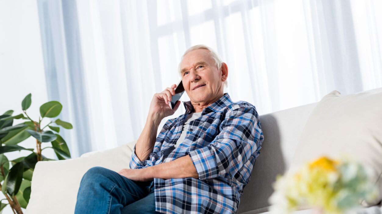 man sitting on sofa whilst on the phone