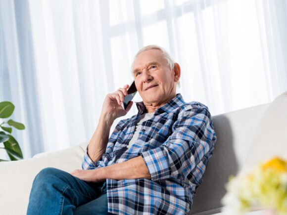 man sitting on sofa whilst on the phone