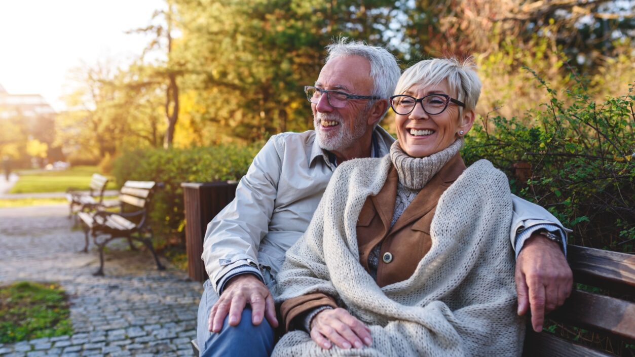mature couple sat happily on a bench