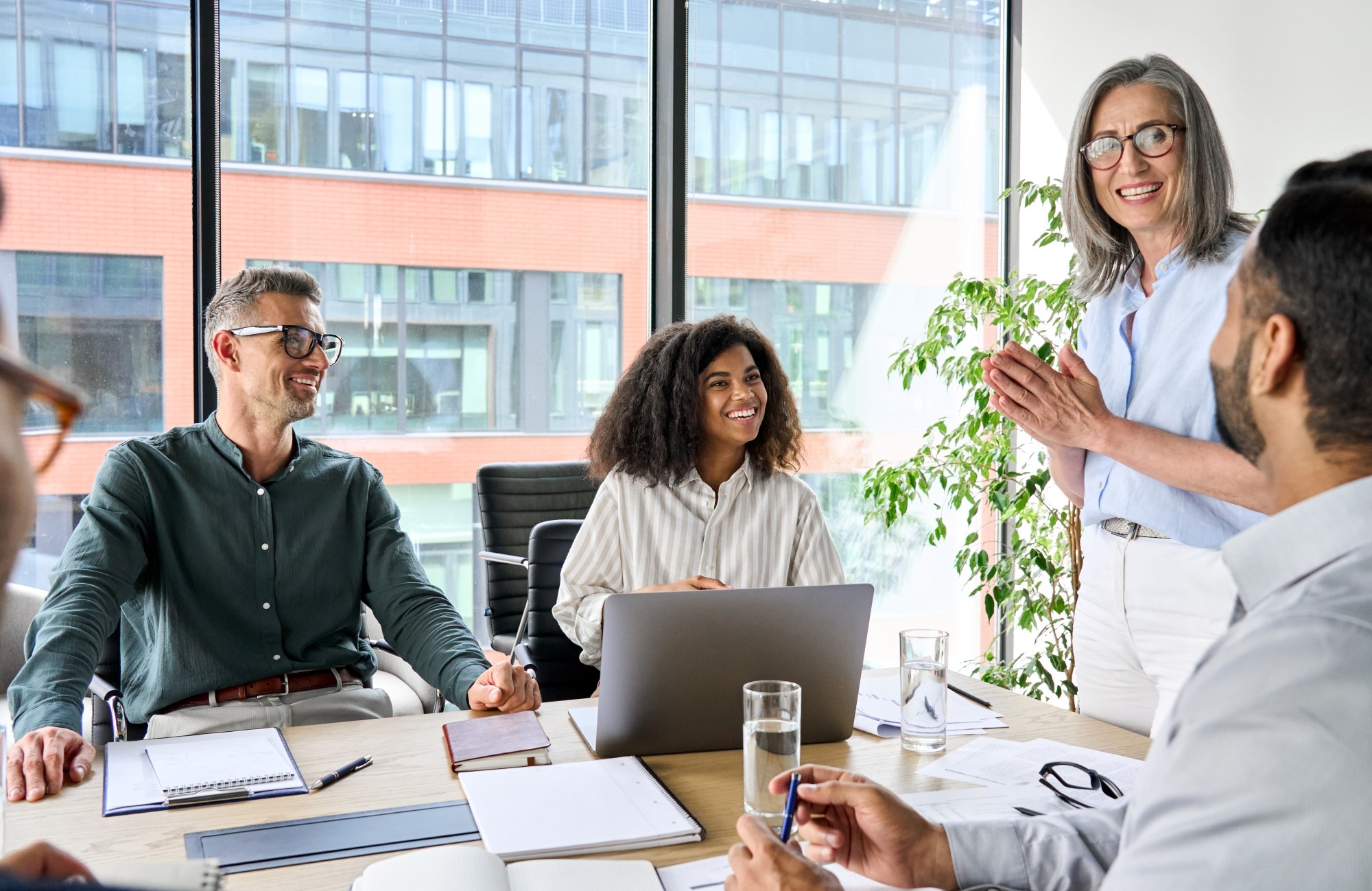 A group of people in a conference room having a meeting and smiling.