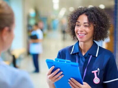 Photo of a healthcare professional looking at another healthcare professional in a hospital setting.