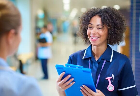 Photo of a healthcare professional looking at another healthcare professional in a hospital setting.