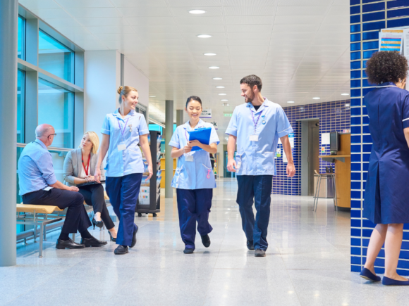 Group of healthcare professionals walking through a hospital corridor.