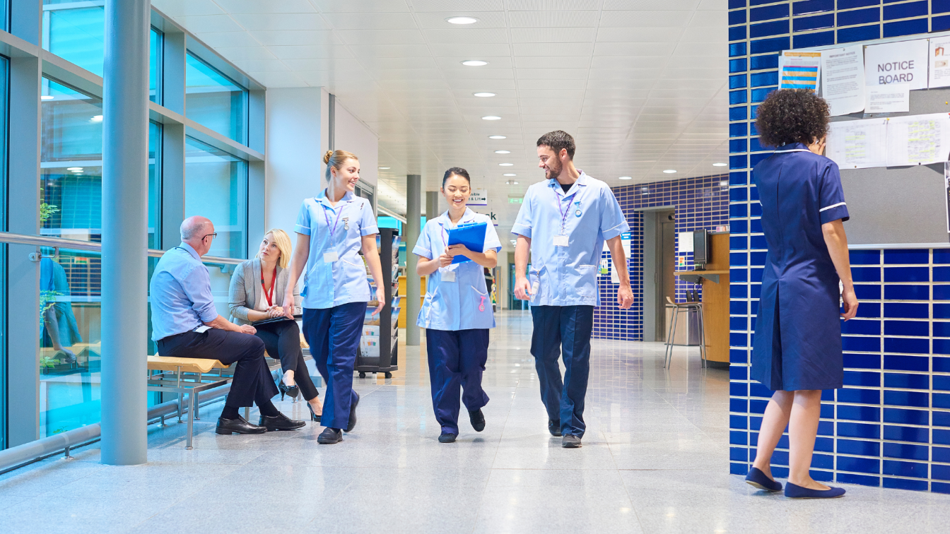 Group of healthcare professionals walking through a hospital corridor.