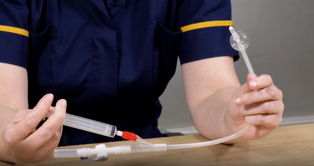 Photo of Louise Harrison, Community Specialist Nurse demonstrating how an indwelling catheter works.