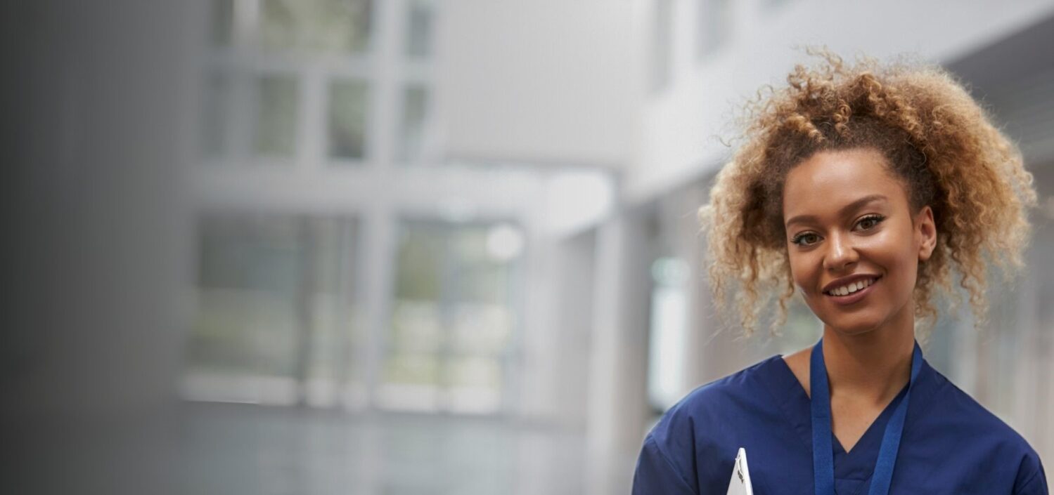 Photo of a healthcare professional smiling in a hospital setting.