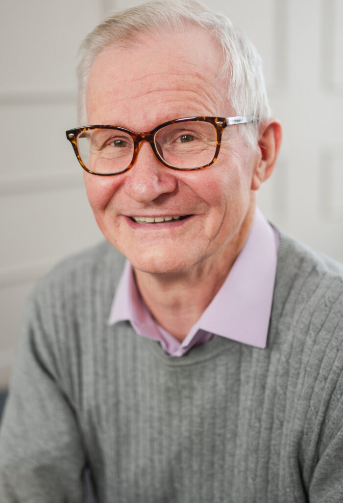 Photo of an elderly man smiling looking towards the camera.