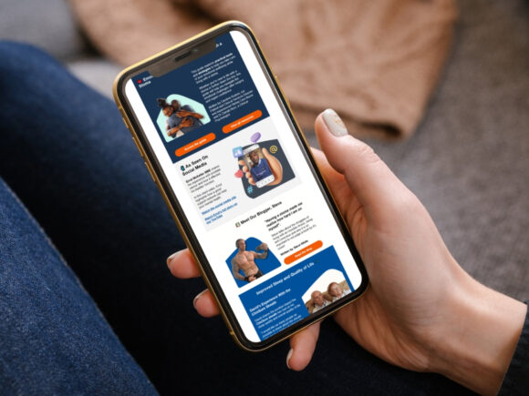 A persons hand, holding a mobile phone and reading an issue of the CliniMed email newsletter.