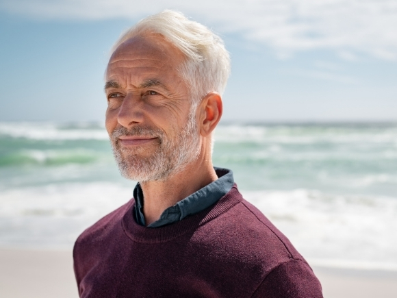 Photo of a man at the beach looking into the distance
