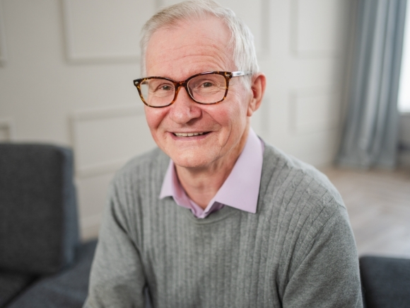 Photo of an elderly man smiling looking towards the camera.