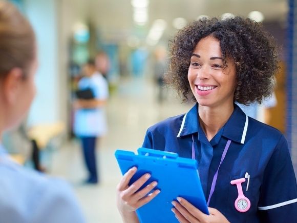 Photo of a healthcare professional looking at another healthcare professional in a hospital setting.