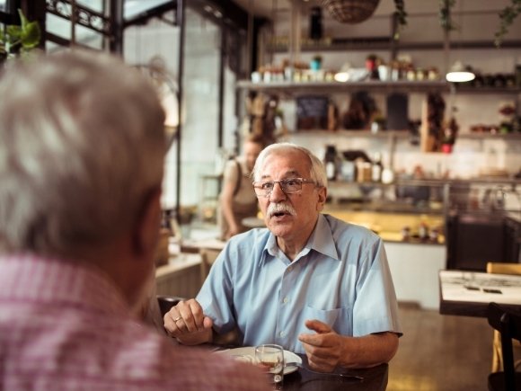 Photo of two men having a conversation in a café