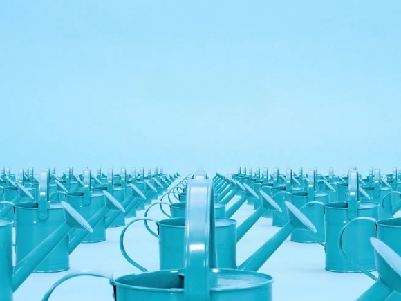 Photo with multiple blue watering cans in columns