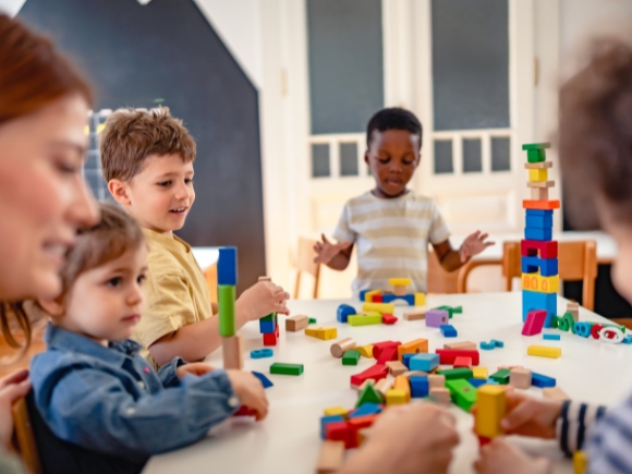 Photo of children sat a table playing with building blocks