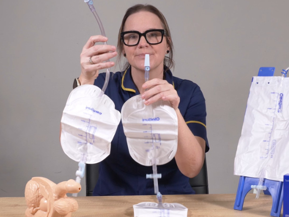 Photo of Anna holding two leg drainage bags